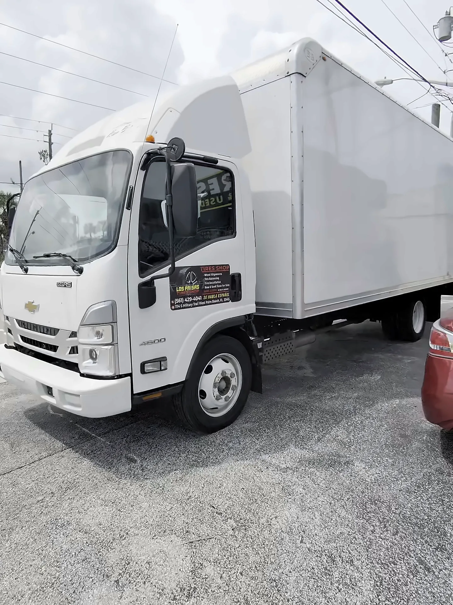 Camión blanco de caja estacionado en el lote del taller