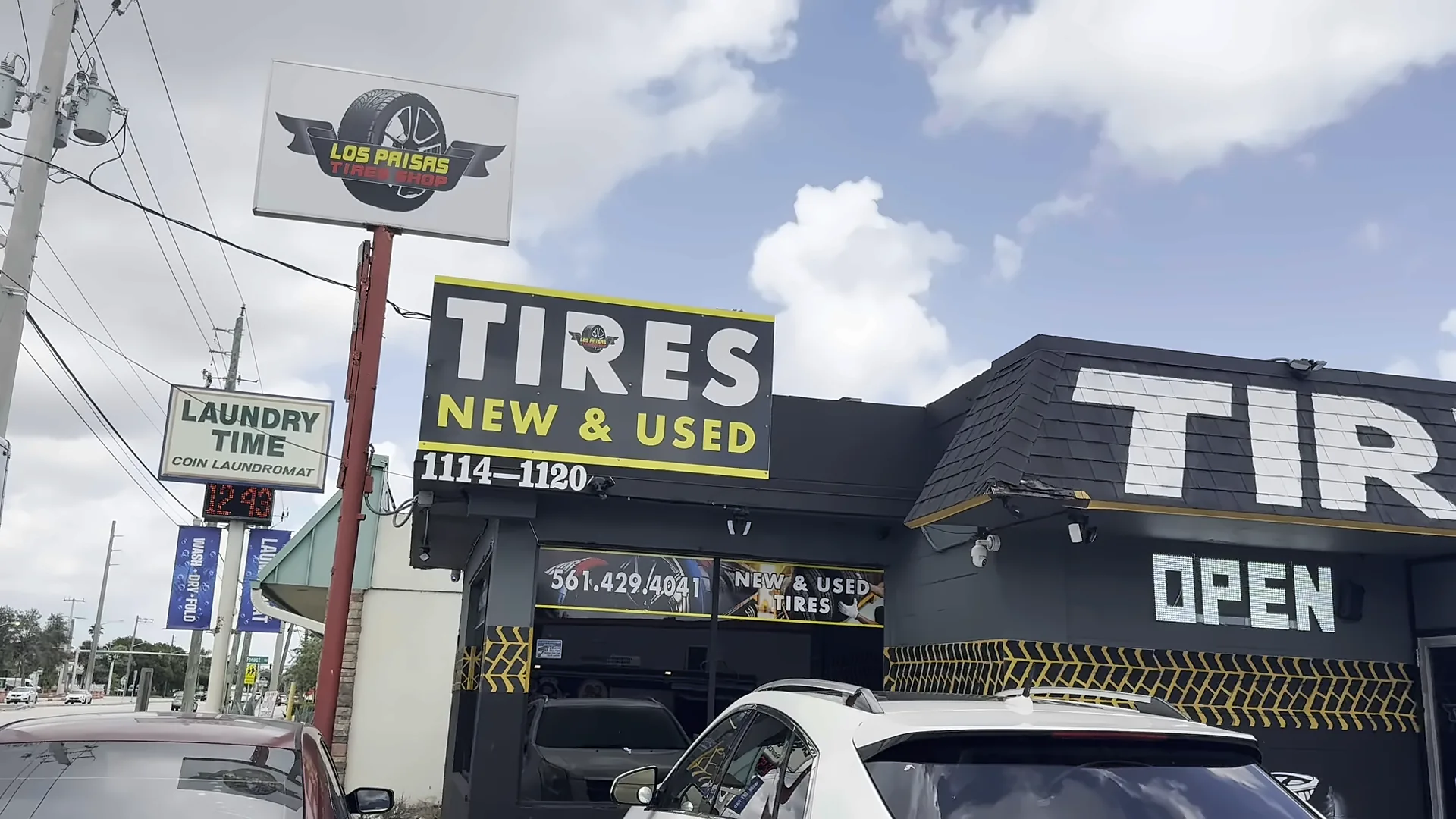 Letrero en poste que dice Tires New & Used frente al taller