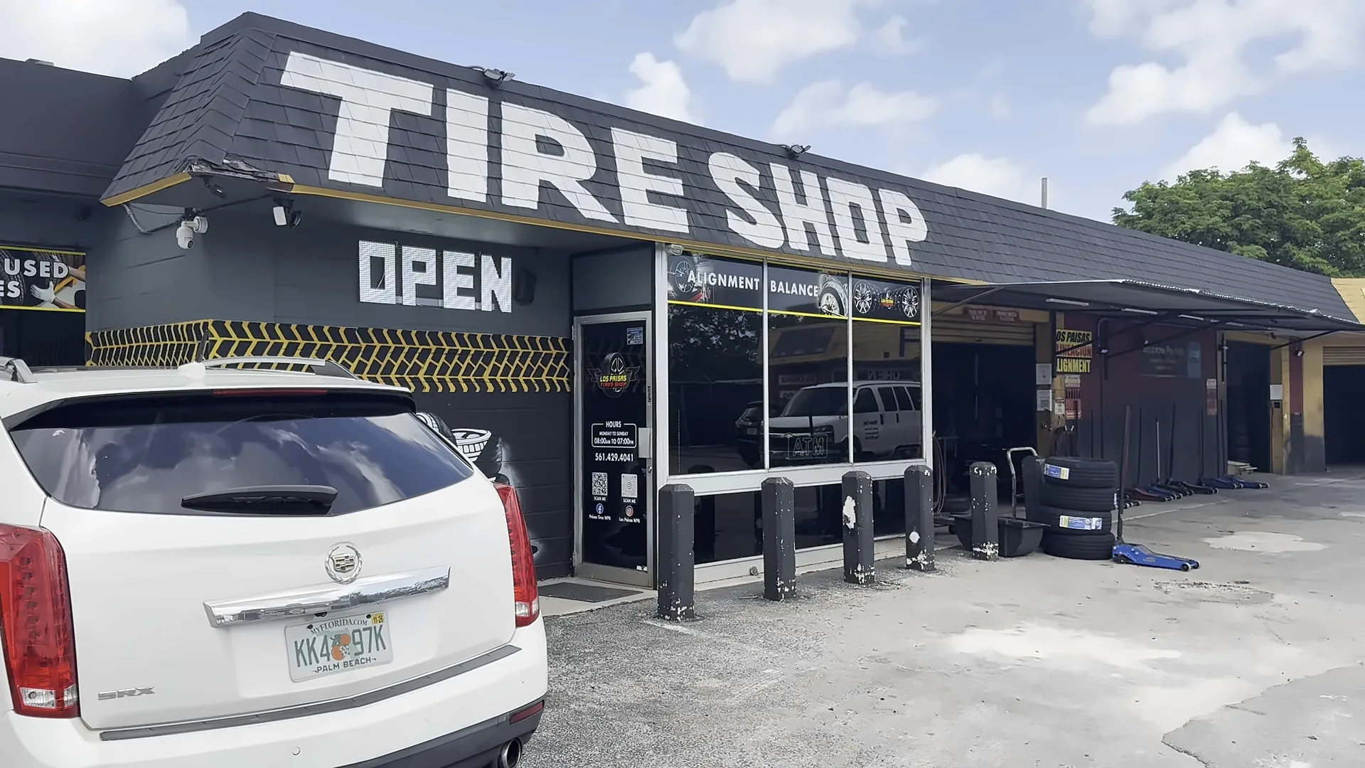 Fachada de Los Paisas Tires Shop con el letrero Tire Shop y el letrero Open